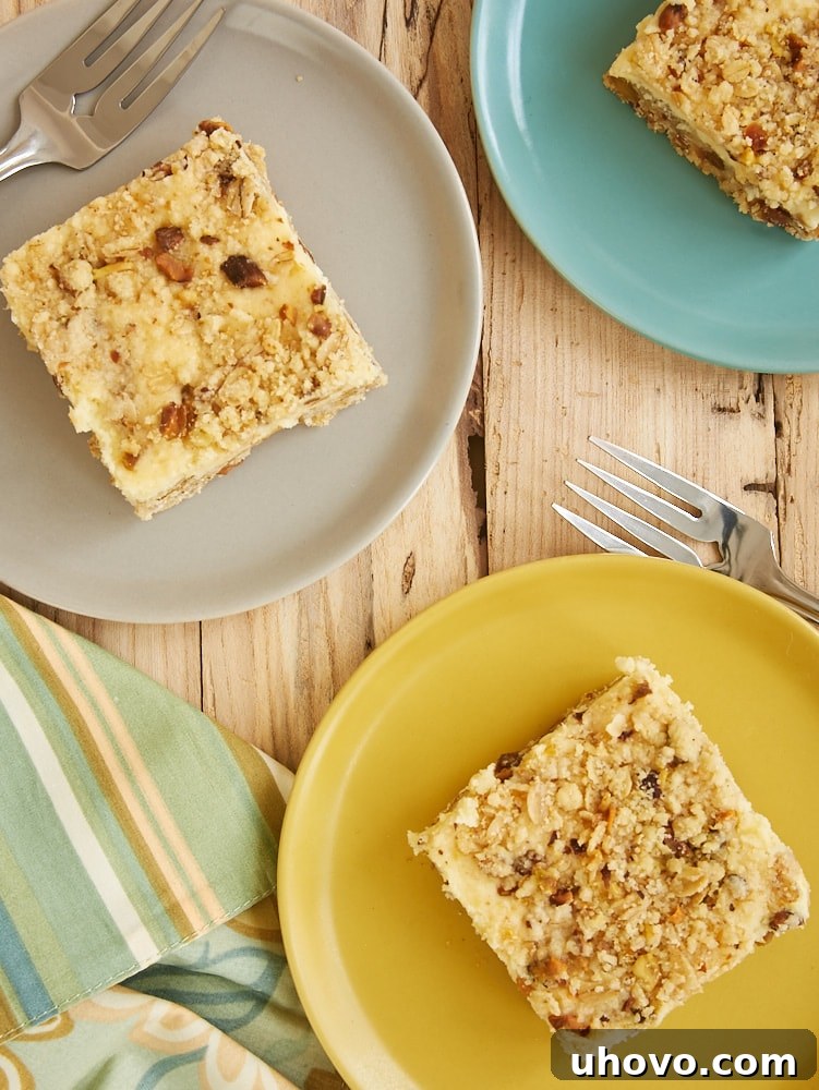 overhead view of Lemon Pistachio Cheesecake Bars on yellow, gray, and blue plates