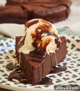 Slice of Easy Chocolate Torte topped with ice cream and chocolate sauce