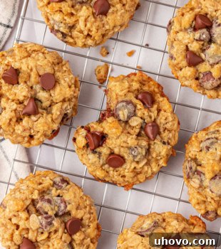Brown sugar oatmeal chocolate chip cookies on a wire rack with a bite missing from the center cookie, emphasizing their delicious, chewy texture.