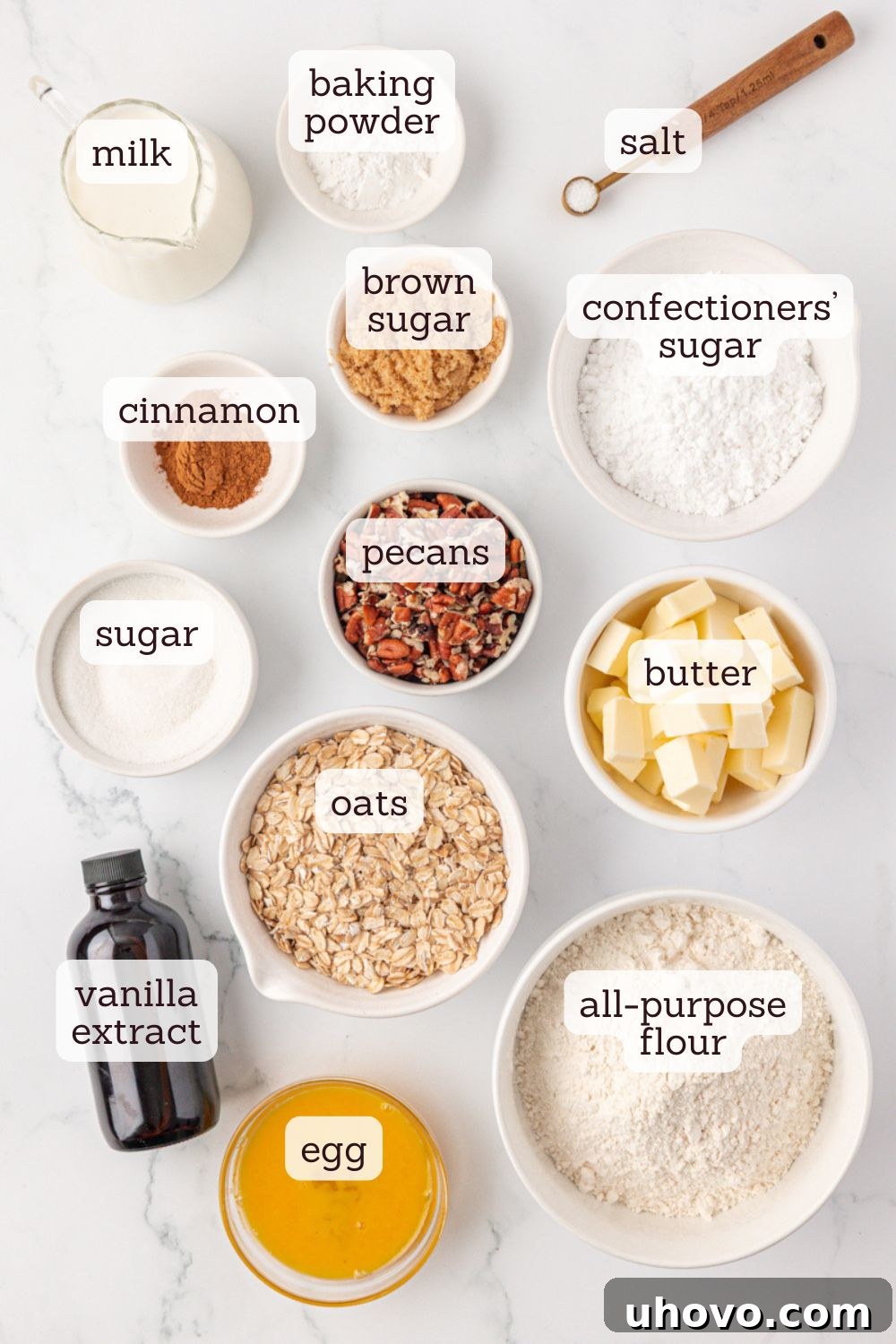 Overhead view of various ingredients laid out for making cinnamon bun scones, including flour, oats, butter, brown sugar, and pecans.