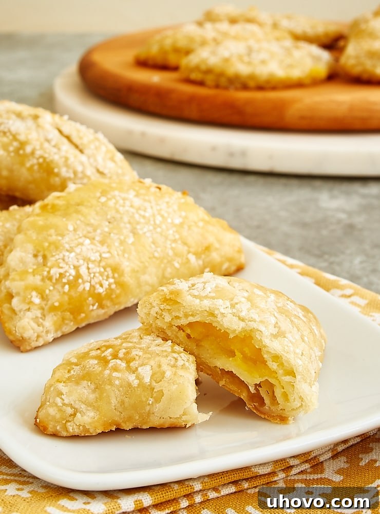 Ginger Lemon Hand Pie cut in half on a white serving plate showing the bright lemon filling