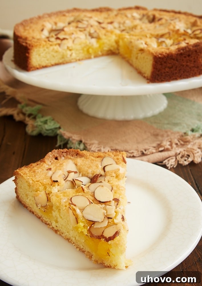 A beautifully sliced Lemon Almond Butter Cake, showcasing its moist texture and pockets of lemon curd, perfect for any occasion.