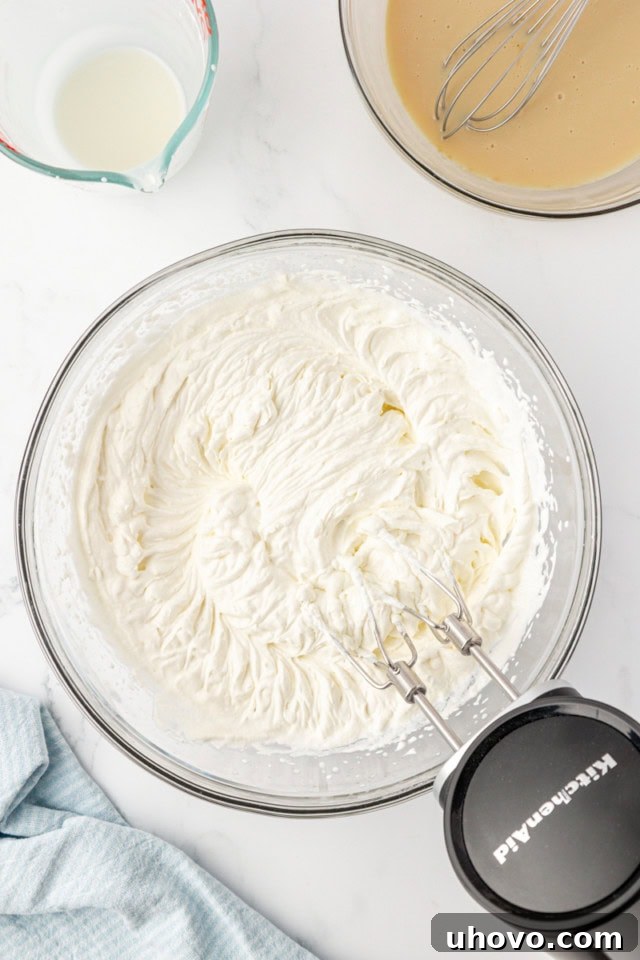 overhead view of whipped cream in a glass mixing bowl