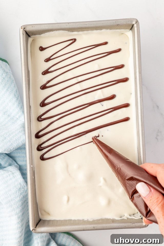 overhead view of melted chocolate being drizzled over vanilla ice cream