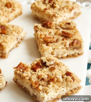 Sliced Pecan Cheesecake Bars on a white serving tray