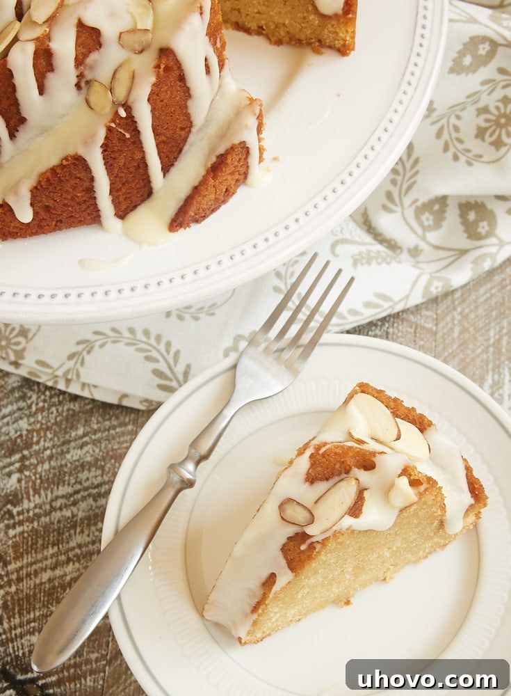 A perfectly sliced piece of Amaretto Almond Bundt Cake revealing its moist interior and generous glaze
