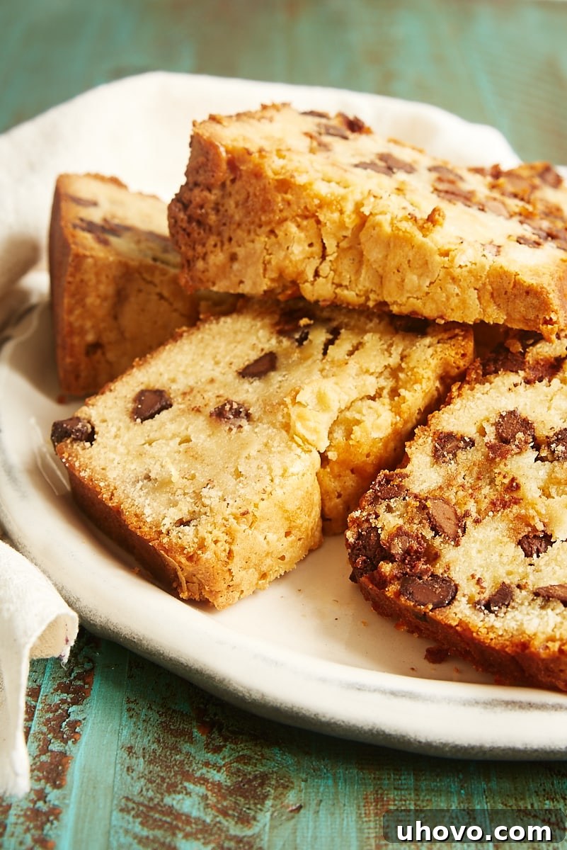 Multiple tempting slices of Chocolate Chip Cream Cheese Pound Cake artfully arranged on a pristine white plate, highlighting the cake's inviting texture and perfect golden-brown crust.
