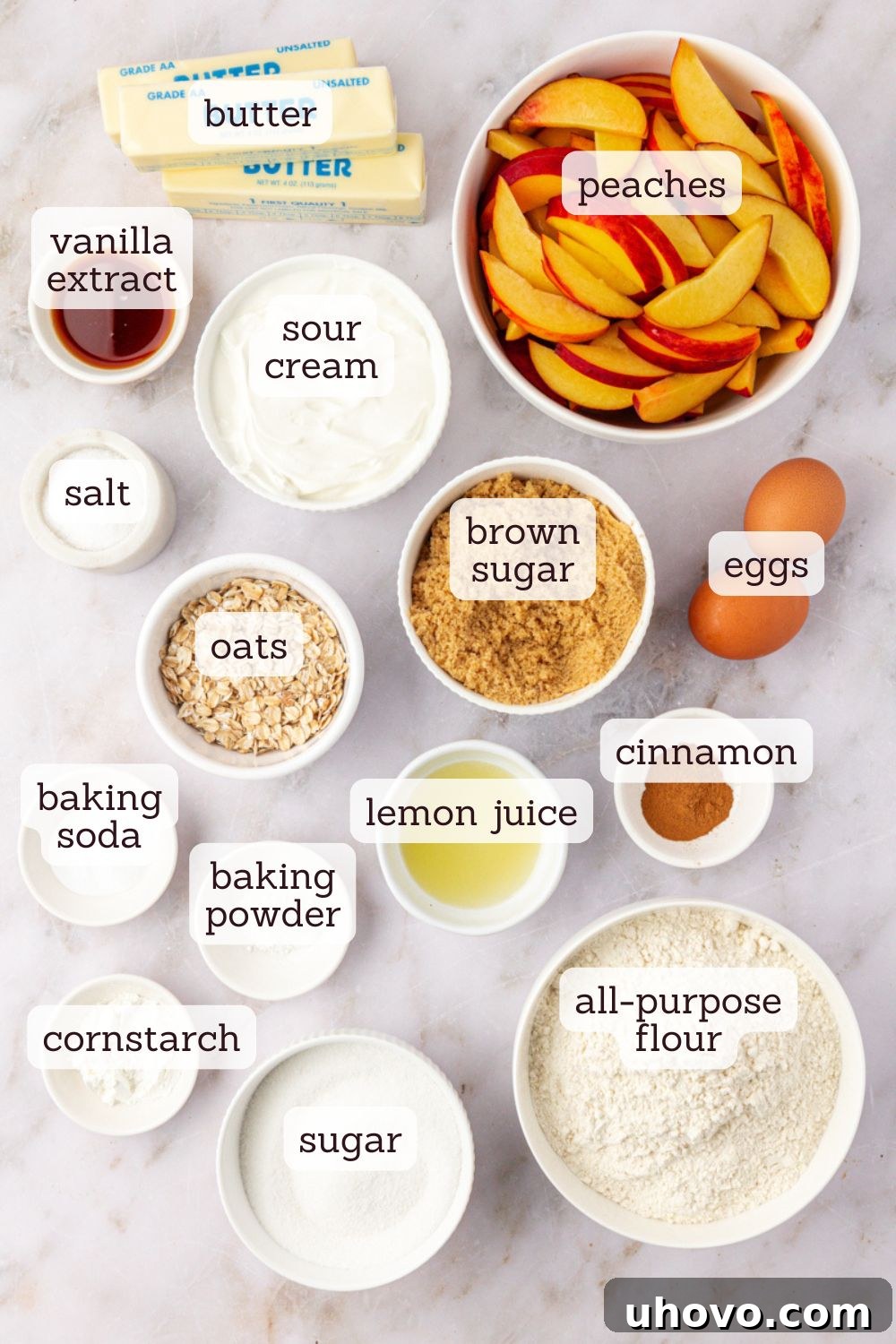 An overhead view showcasing all the fresh, high-quality ingredients laid out for making a delicious peach coffee cake, including ripe peaches, flour, sugar, butter, and sour cream.