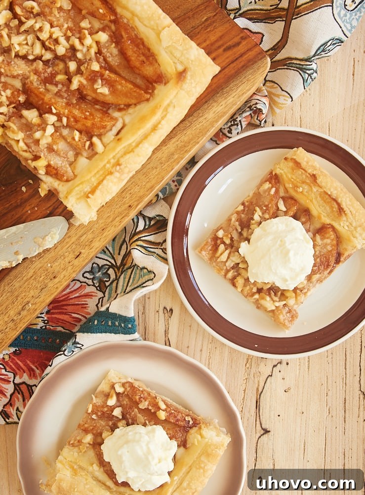 slices of Cream Cheese-Filled Pear Tart topped with sweetened whipped cream