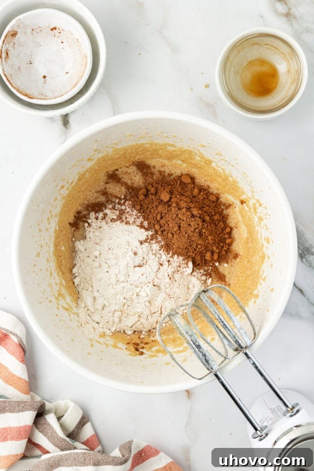 Dry ingredients for cookie dough added to wet ingredients, ready for mixing