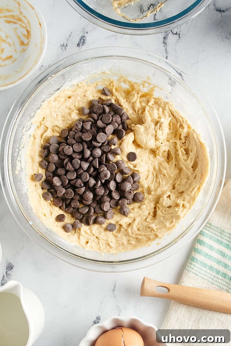 Overhead view of semisweet chocolate chips being added to the prepared peanut butter bread batter.