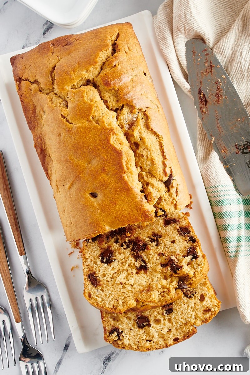Overhead view of a partially sliced loaf of Chocolate Chip Peanut Butter Bread, revealing its moist interior.