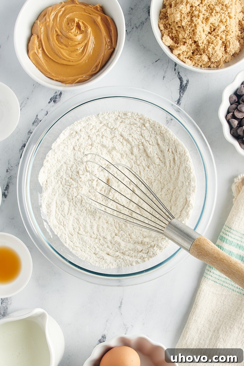 Overhead view of dry ingredients thoroughly mixed in a glass mixing bowl, ready for the wet ingredients.