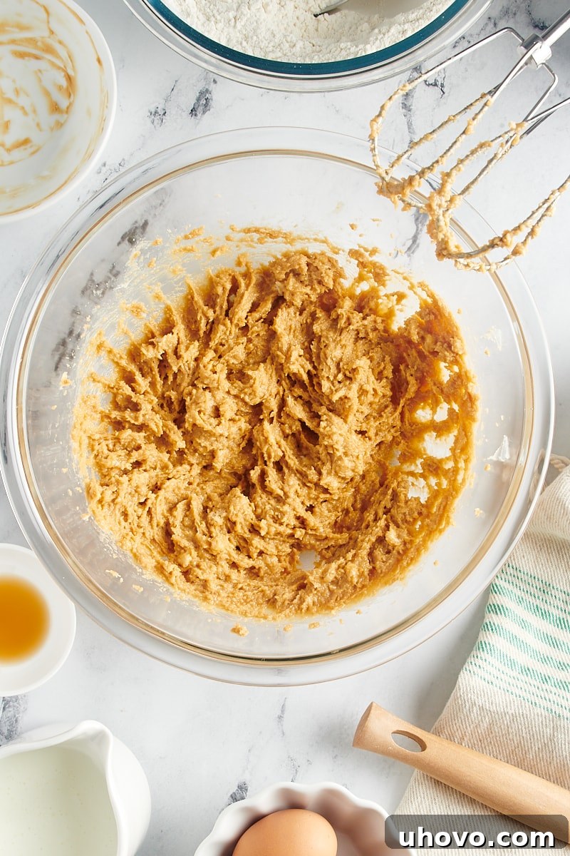 Overhead view of butter, brown sugar, and peanut butter creamed together until light and fluffy in a mixing bowl.