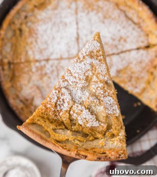 overhead view of a slice of Dutch baby pancake lifting away from the remaining pancake