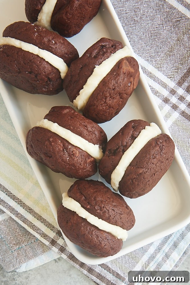 Delicious Brownie Cookie Sandwiches displayed on a rustic wooden tray, showcasing their rich, fudgy texture and creamy white filling.