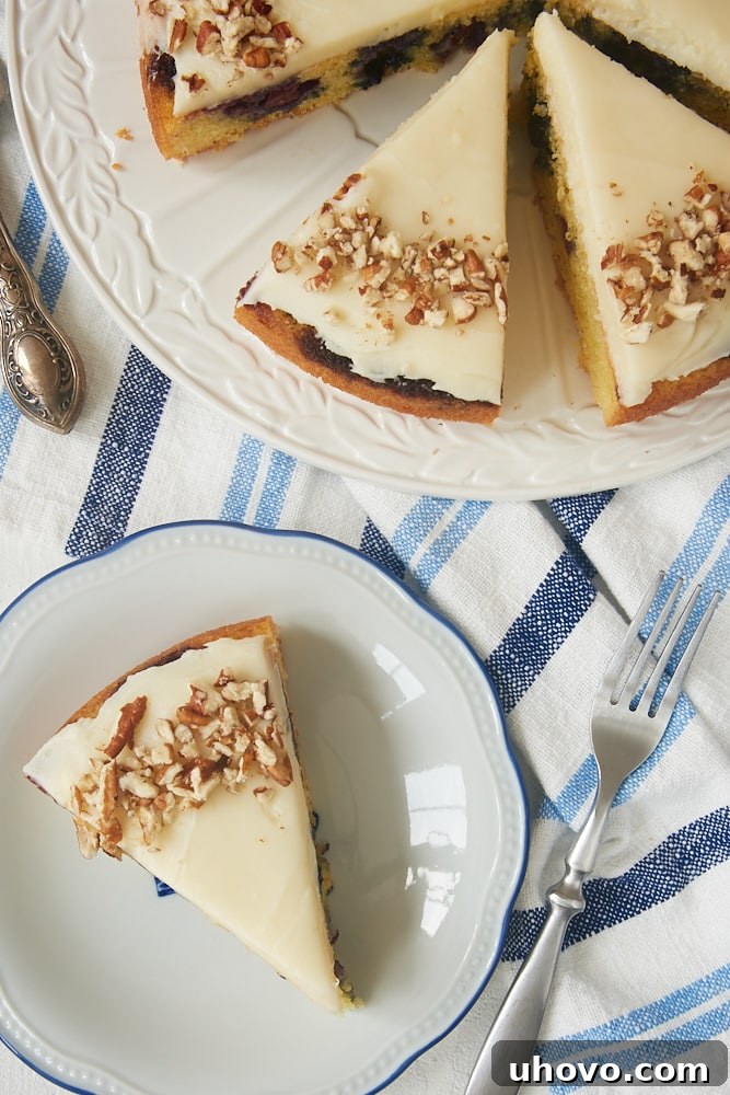 Close-up of several slices of Blueberry Snack Cake, each topped with fluffy cream cheese frosting, presented beautifully