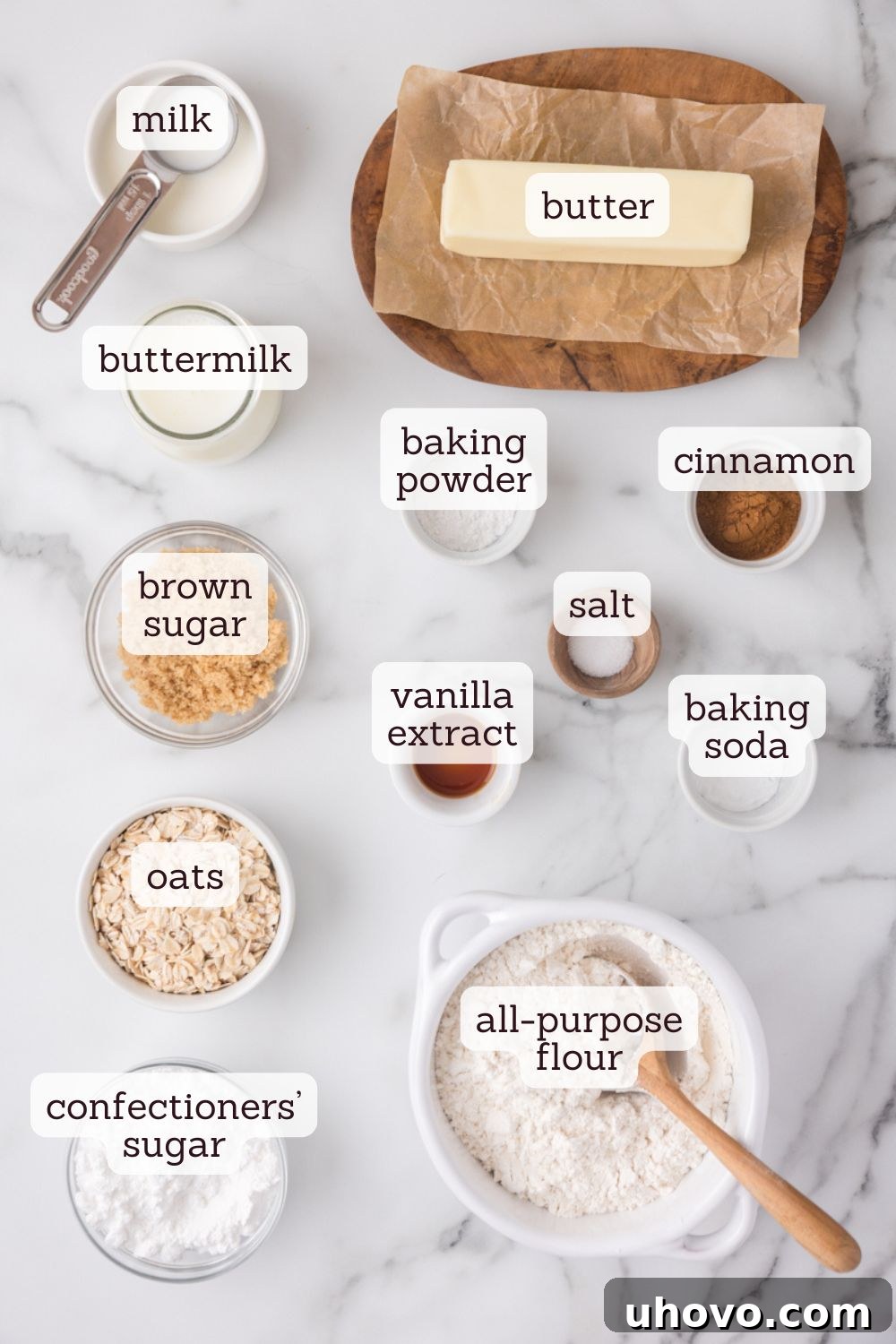 Overhead view of various key ingredients for cinnamon oat scones laid out, including flour, oats, butter, and cinnamon.