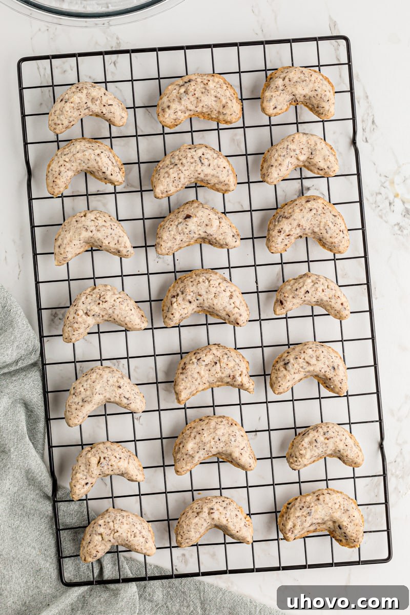 Overhead view of delicate hazelnut crescent cookies cooling on a metal wire rack