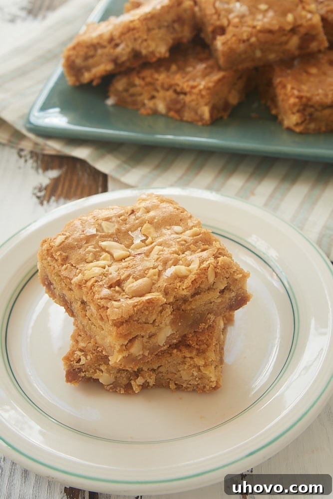 Close-up of baked Caramel Peanut Blondies with visible peanuts and gooey caramel.