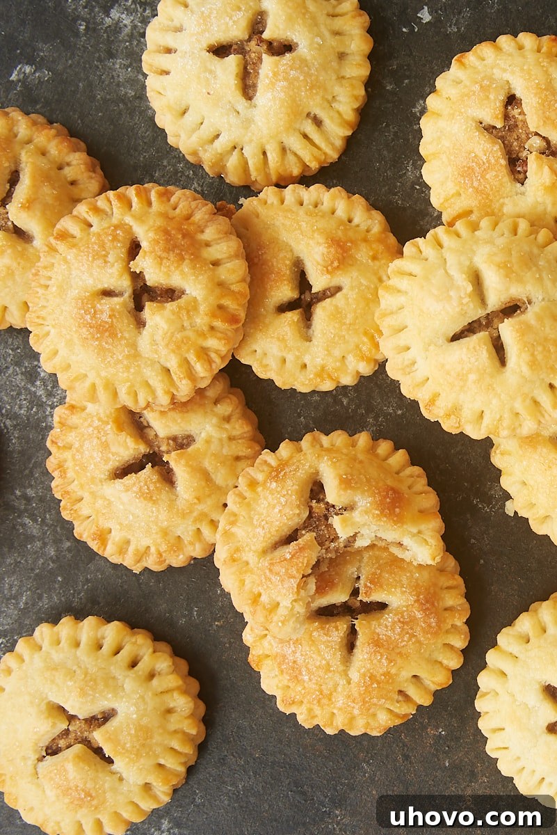 Overhead view of several Pecan Hand Pies piled artfully on a dark surface.