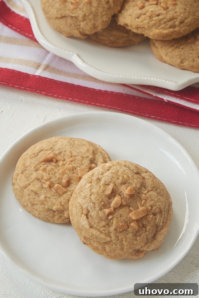 Freshly baked Spiced Toffee Cookies cooling on a wire rack, garnished with turbinado sugar and extra toffee bits.