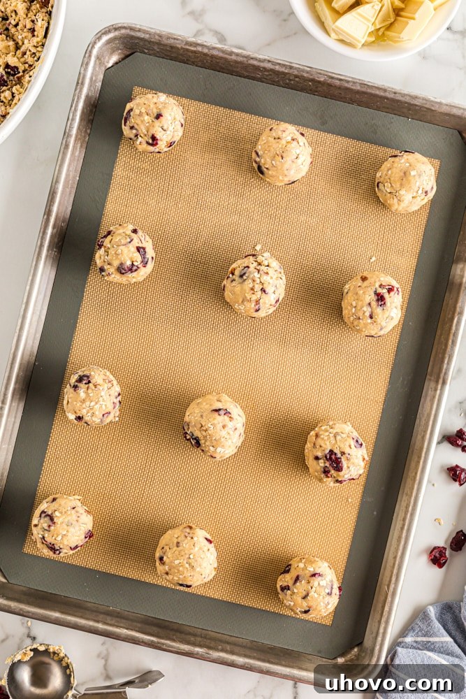 overhead view of portioned Oatmeal Cranberry Cookies dough on a silicone-lined baking pan