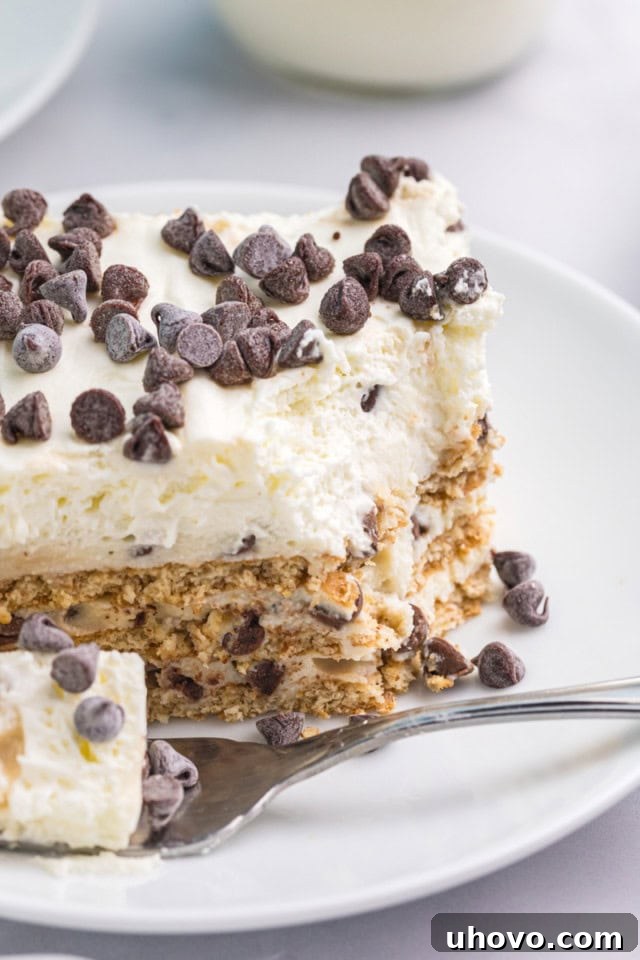 close-up view of a slice of cannoli icebox cake on a white plate with a bite on a fork
