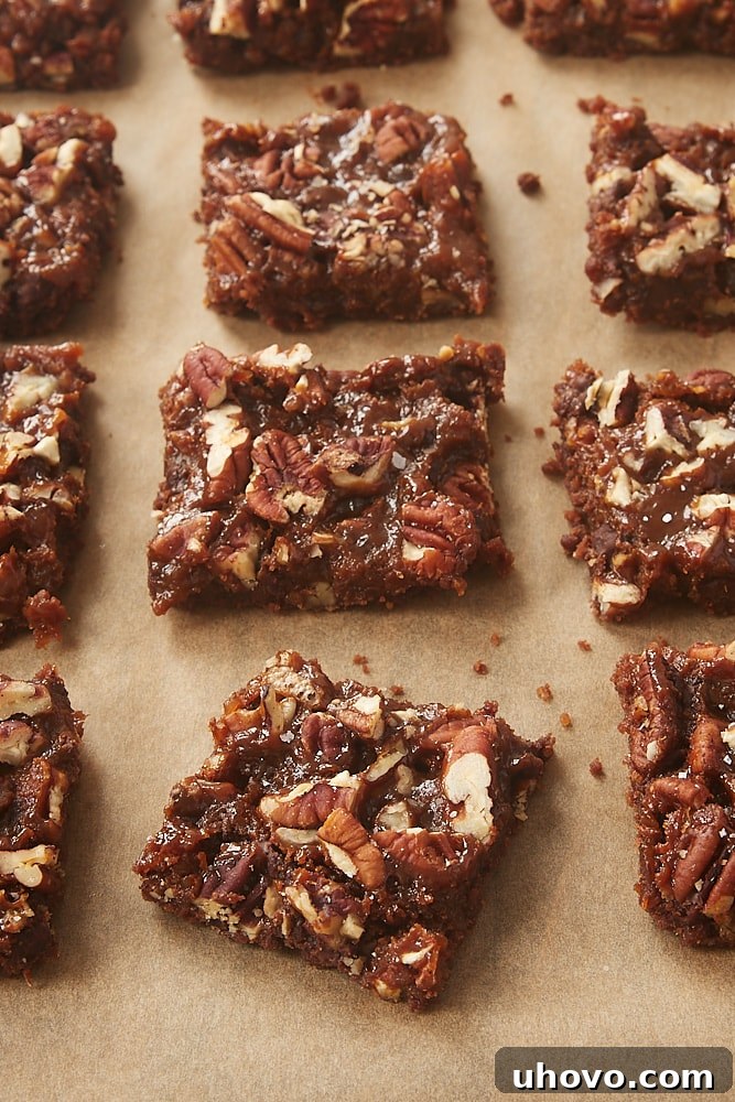 Close-up of baked Dulce de Leche Magic Bars, showing the top layer of pecans and golden dulce de leche peeking through.