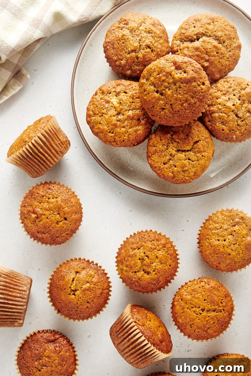 Overhead view of delicious Banana Nut Muffins on a plate and scattered on a white surface