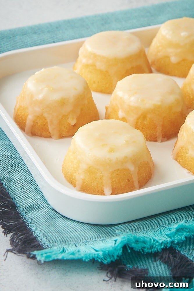 Mini Lemon Pound Cakes arranged beautifully on a white serving tray, each topped with a delicate lemon glaze, evoking a fresh and inviting feel.