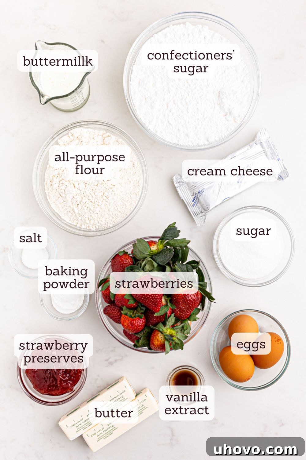 A vibrant overhead view of all the essential ingredients laid out for baking a delicious strawberry sheet cake, ready for preparation.