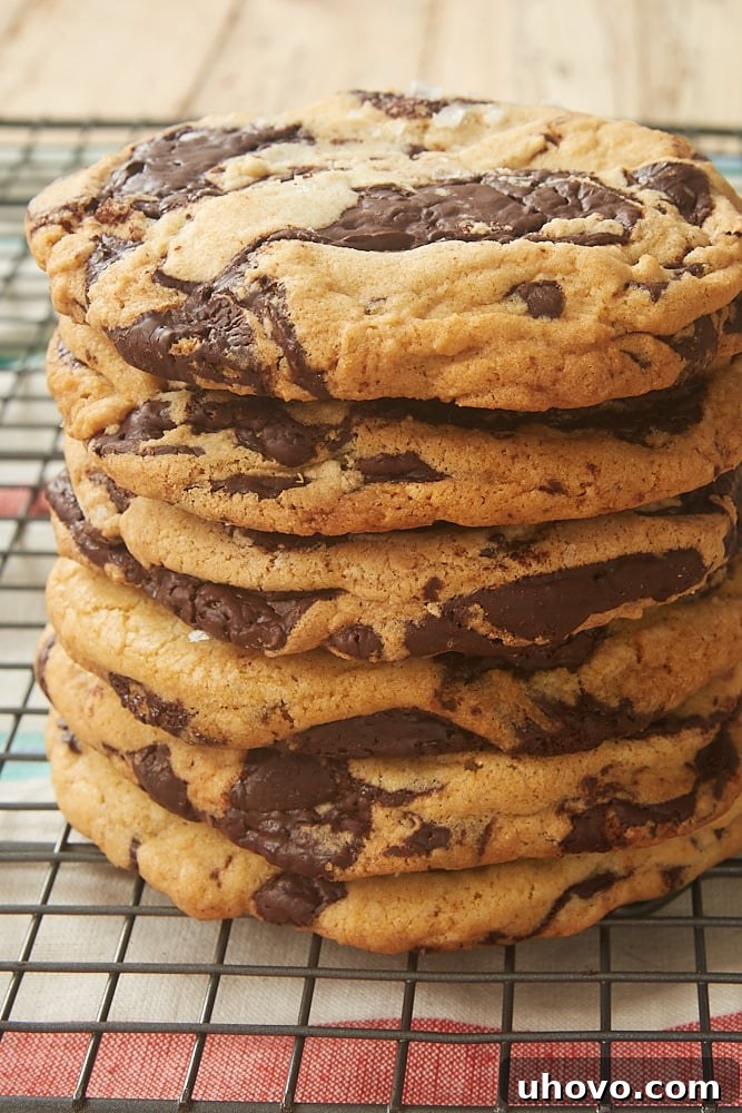 Stack of freshly baked Jacques Torres Chocolate Chip Cookies, showcasing their thick, chewy texture and abundant chocolate puddles.