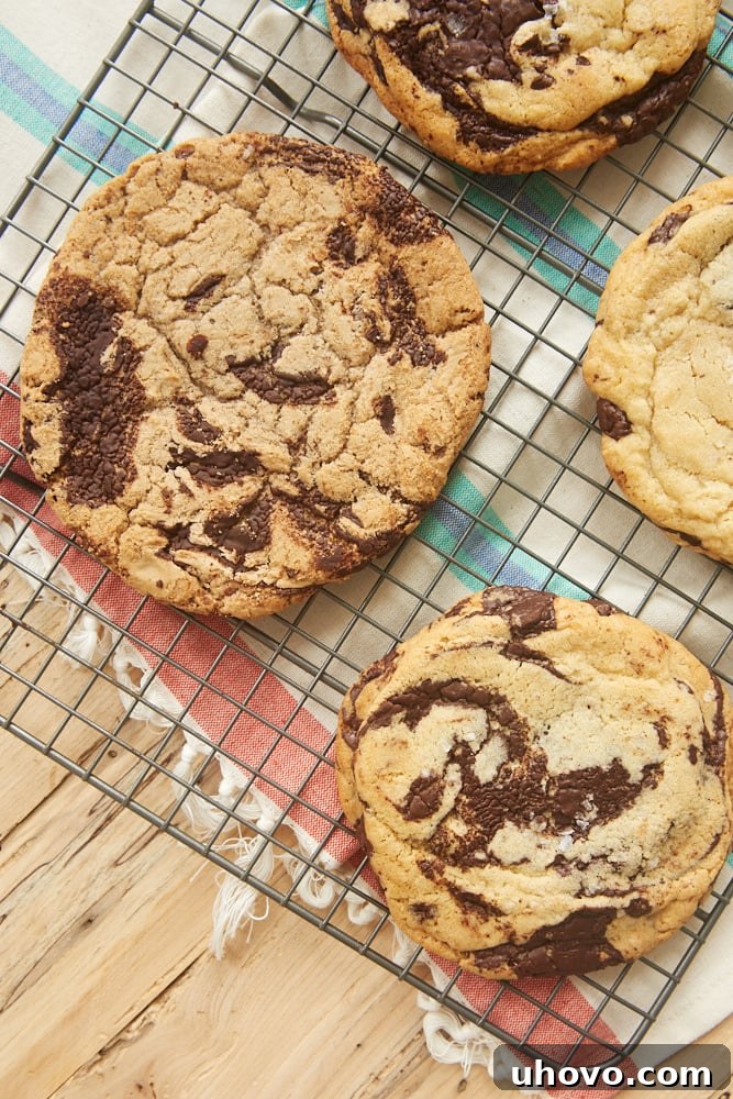 A side-by-side comparison of homemade Jacques Torres Chocolate Chip Cookies and store-bought originals, highlighting their similar impressive size and chocolate content.