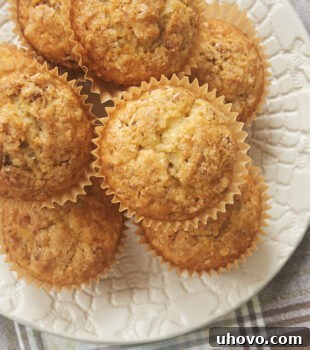 Brown Butter Coconut Pecan Muffins on a white plate, showcasing their inviting texture