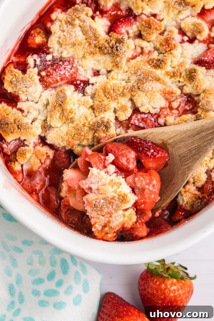 A bowl of Strawberry Cobbler topped with a unique cream cheese biscuit.