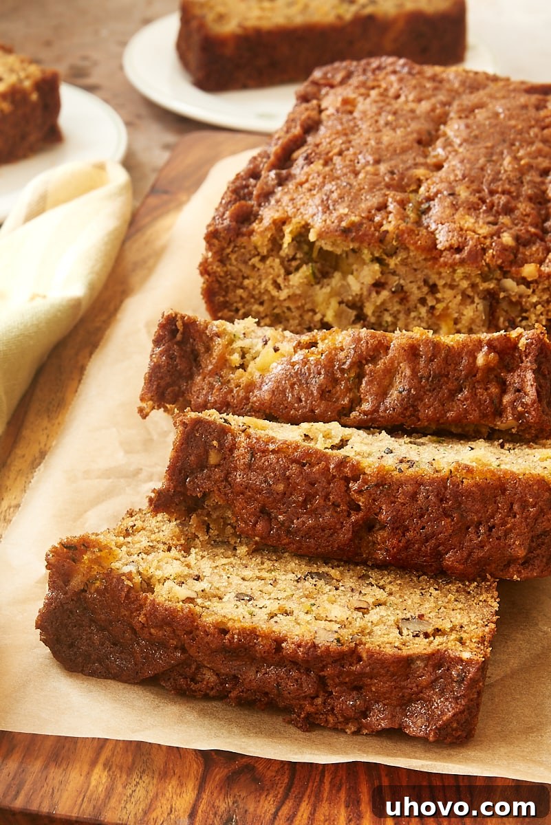 Sliced Pineapple Zucchini Bread on a rustic wooden cutting board, with more slices in the background, highlighting its golden crust and moist interior.