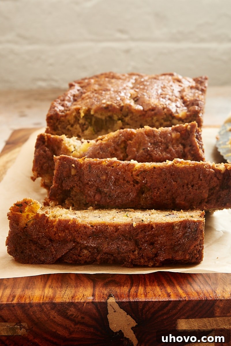 A perfectly baked loaf of Pineapple Zucchini Bread, sliced on a cutting board, ready to be served, emphasizing its golden-brown crust.