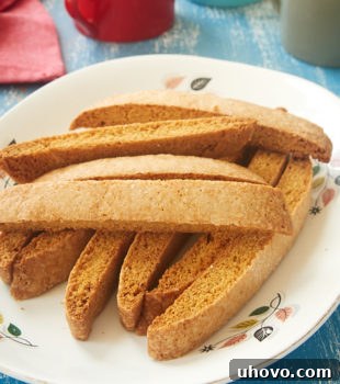 Vanilla Biscotti stacked on a white plate with a floral rim
