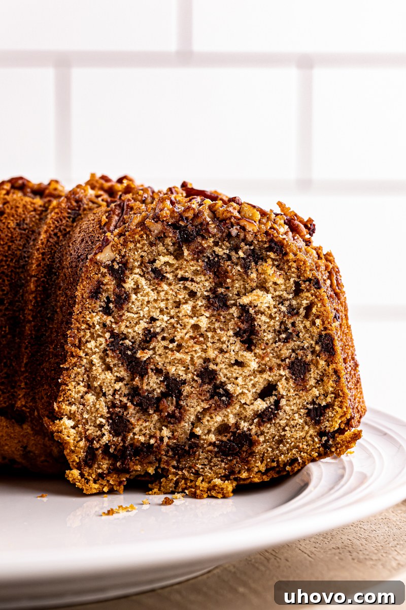 partially sliced chocolate chip Bundt cake on a white cake plate