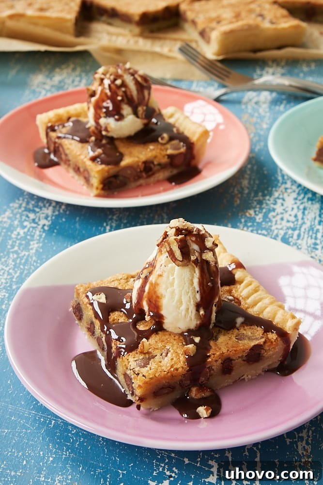 Generous slices of Double Chocolate Chip Slab Pie, beautifully topped with creamy vanilla ice cream, rich chocolate syrup, and a sprinkle of chopped nuts, ready to be served.