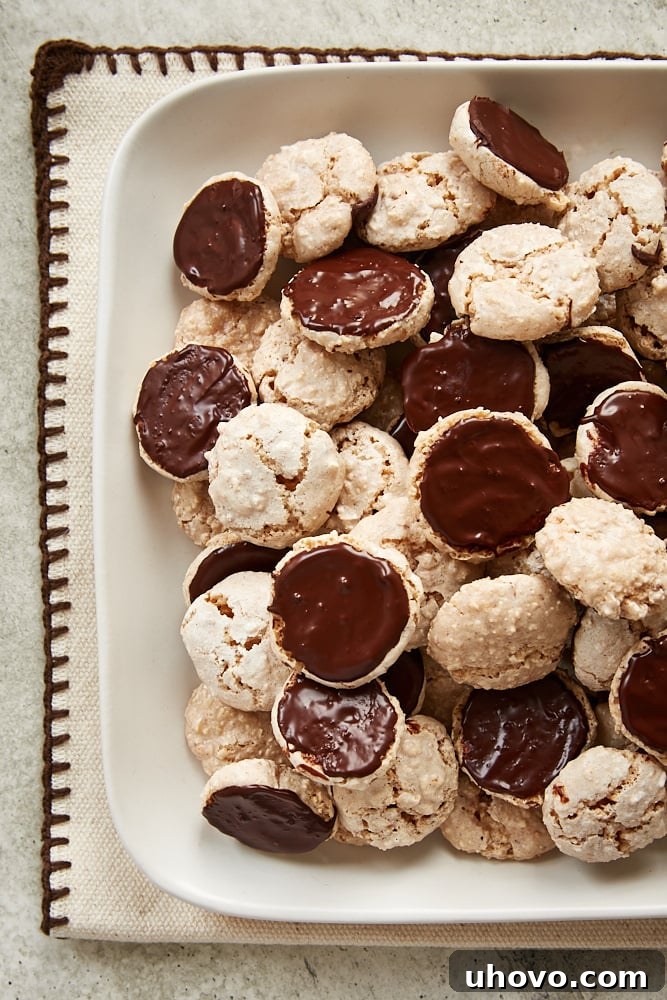 A generous pile of homemade Hazelnut Macaroons on a pristine white serving tray, ready to be enjoyed.