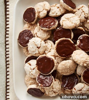 Hazelnut Macaroons piled on a white serving tray, highlighting their delightful form and texture.