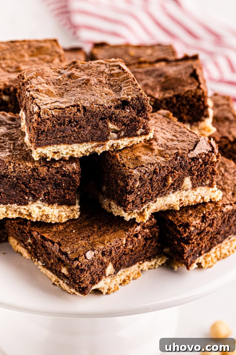 A generous pile of rich Nutella-Salted Shortbread Brownies artfully arranged on a cake stand, highlighting their fudgy texture and delicious layers.