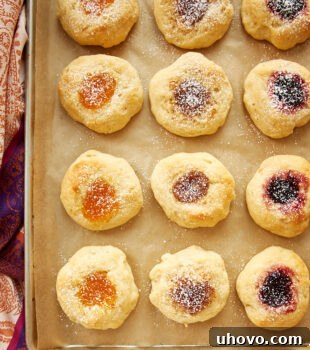 Overhead view of kolaches on a parchment-lined baking sheet, ready to be enjoyed