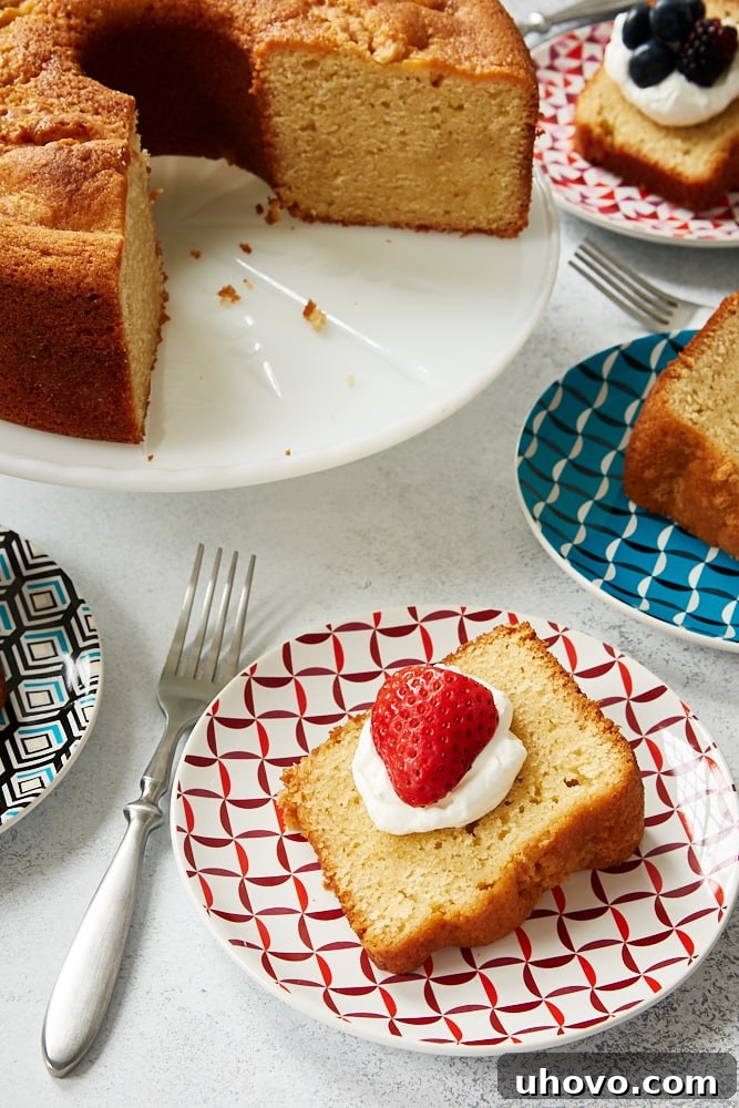 A stunning Sour Cream Pound Cake presented on a pristine white cake stand, surrounded by individual slices, highlighting its golden crust and inviting texture.