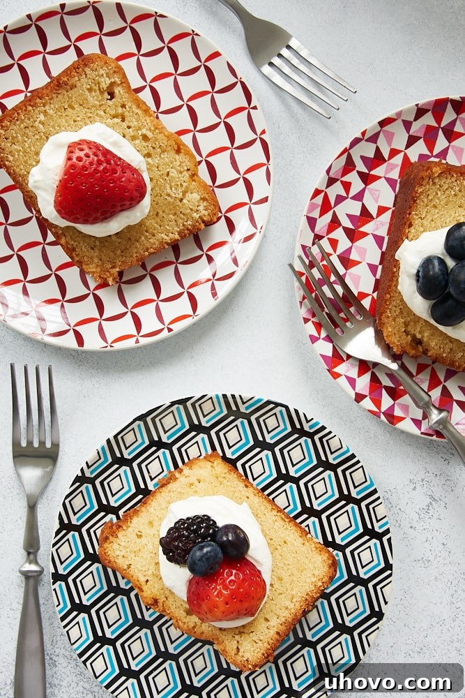 Three generous slices of Sour Cream Pound Cake artfully arranged on colorful plates, ready to be enjoyed as a delightful dessert.