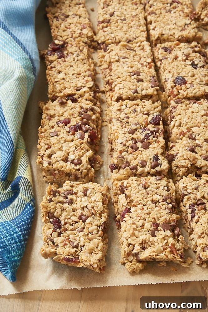Cranberry Chocolate Chip Pecan Granola Bars on a sheet of parchment paper, ready to be cut