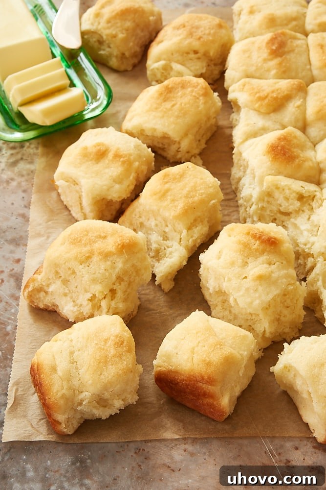 Freshly baked Angel Biscuits cooling on parchment paper, ready to be enjoyed.