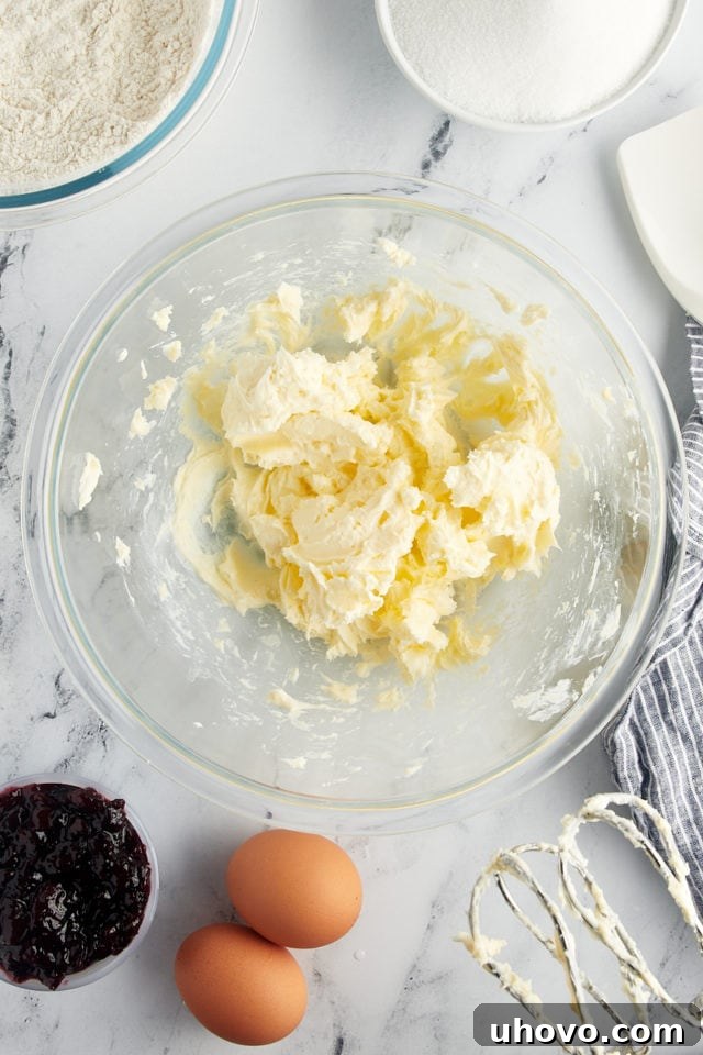 An overhead view of perfectly creamed unsalted butter in a glass mixing bowl, light and fluffy.